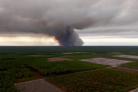 Large cloud of grey and black smoke rising in the distance